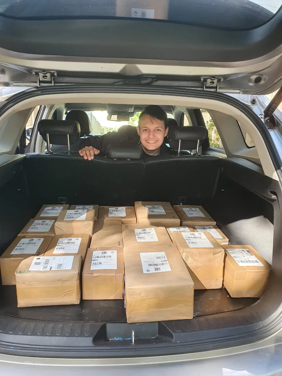 Lote de pedidos VEX prontos para envio no porta-malas.